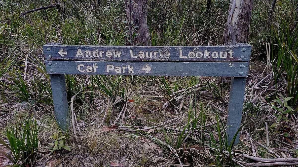 A timber walking track sign pointing to a lookout and car park in the bush